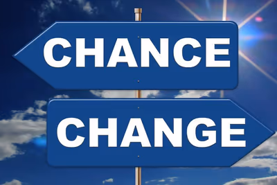 Zwei blaue Wegweiser mit den Aufschriften Chance und Change vor blauem Himmel