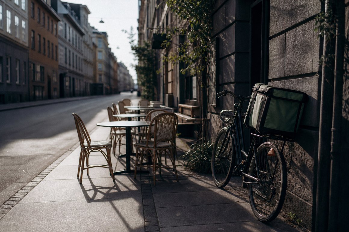Leere Tische und Stühle auf einem schmalen Gehweg am späten Vormittag